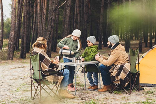 family sitting around camping table